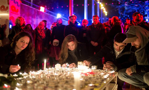 People light candles to pay tribute to the victims of the Paris attacks that killed more than 120 people. (Photo: AP) People light candles to pay tribute to the victims of the Paris attacks that killed more than 120 people. (Photo: AP)